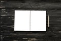 Empty open notebook and silver pen on the black wooden background Royalty Free Stock Photo