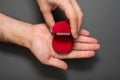 Empty open red jewelry box in a male hands. Present. Black background. Top view Royalty Free Stock Photo