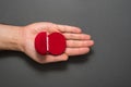 Empty open red jewelry box in male palm. Present. Black background. Top view Royalty Free Stock Photo