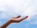 Empty open woman hand or face up hand against with blue sky and white clouds Royalty Free Stock Photo