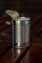 Empty opened tin can of food side view no labels set on wooden table blurry background Royalty Free Stock Photo