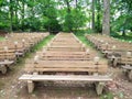 Empty outdoor benches surrounding by green trees