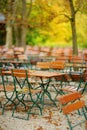 Empty outdoor cafe on autumn day in Munich, Germany. Empty chiars and tables under chestnut trees in autumn season.