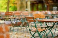 Empty outdoor cafe on autumn day in Munich, Germany. Empty chiars and tables under chestnut trees in autumn season.