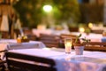 Empty outdoor cafe at dusk. Stylish table decoration with borning candle and natural plant