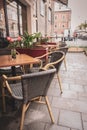 Empty outdoor cafe during quarantine. Restaurant terrace with tables and chairs. Flower on table of street cafe. Royalty Free Stock Photo