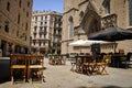 Empty outdoor cafe with wooden chairs and tables in the gothic quarter of Barcelona, Spain