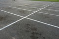 Empty outdoor dirty parking lot space marked with white lines