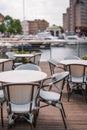 Empty outdoor restaurant tables and chairs in St Katherine\'s Dock, London, UK Royalty Free Stock Photo