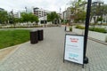 Empty outdoor shopping mall with informative signage during COVID-19 pandemic.