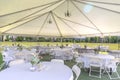 Empty Outdoor Wedding Pavilion with Tables and Chairs Under Tent