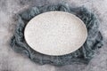 Empty oval plate with gauze on concrete