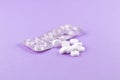 Empty pack with white pills packed in blister with copy space on purple background. Focus on foreground, soft bokeh Royalty Free Stock Photo