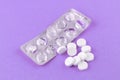 Empty pack with white pills packed in blister with copy space on purple background. Focus on foreground, soft bokeh Royalty Free Stock Photo