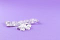 Empty pack with white pills packed in blister with copy space on purple background. Focus on foreground, soft bokeh Royalty Free Stock Photo