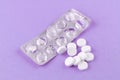 Empty pack with white pills packed in blister with copy space on purple background. Focus on foreground, soft bokeh Royalty Free Stock Photo