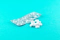 Empty pack with white pills packed in blister with copy space on turquoise background. Focus on foreground, soft bokeh. Pharmacy d Royalty Free Stock Photo