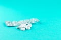 Empty pack with white pills packed in blister with copy space on turquoise background. Focus on foreground, soft bokeh. Pharmacy d Royalty Free Stock Photo