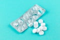 Empty pack with white pills packed in blister with copy space on turquoise background. Focus on foreground, soft bokeh. Pharmacy d Royalty Free Stock Photo