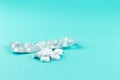 Empty pack with white pills packed in blister with copy space on turquoise background. Focus on foreground, soft bokeh. Pharmacy d Royalty Free Stock Photo