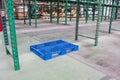 Empty pallet in warehouse interior with shelves, pallets and boxes