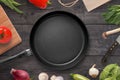 Empty pan on a kitchen table surrounded by vegetarian cuisine ingredients