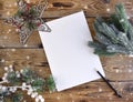 Empty paper blank with Christmas decoration, pencil and fir tree branches on snowy wooden background Royalty Free Stock Photo