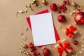 Empty paper blank for Christmas or New year greeting card. Gift boxes, holiday decorations on golden background top view. Flat lay Royalty Free Stock Photo