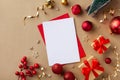 Empty paper blank for Christmas or New year greeting card. Gift boxes, holiday decorations, fir tree on golden background.Flat lay