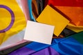 Empty paper blank on Rainbow LGBTQIA flag made from silk material. Mock up template copy space for your text. Symbol of