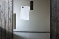 Empty Paper Sheet On Fridge Door - Infront Of Wooden Wall Royalty Free Stock Photo