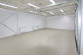 Empty parking garage, warehouse interior with large white gates and gray tile floor