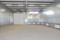 Empty parking garage, warehouse interior with large white gates and windows inside