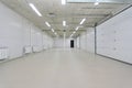 Empty parking garage, warehouse interior with large white gates and windows inside