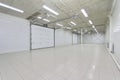 Empty parking garage, warehouse interior with large white gates and windows inside