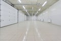 Empty parking garage, warehouse interior with large white gates and windows inside