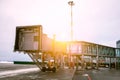 Empty passenger boarding bridge at the winter airport apron in sun light