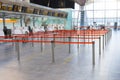 Empty passenger terminal at the airport. Paths limited and separated by a red flight to the check-in desk