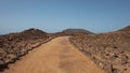 Empty path through the rough and arid landscape of Lobos Island, Fuerteventura, Canary Islands, Spain