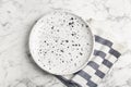 Empty patterned plate and napkin on marble table, flat lay Royalty Free Stock Photo