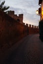 An empty paved road, next to the crenelated stone walls, at dusk, Tuscania, Tuscia, Lazio, Italy