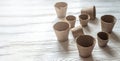 empty peat pots on wooden white table. pots for seedlings, seed tanks for home gardening. Background with peat pots. Spring Royalty Free Stock Photo