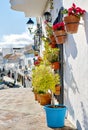 Empty pedestrian footpath and hanging flower pots on residential houses wall, charming small village of Mijas, Costa del Sol Royalty Free Stock Photo