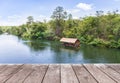 Old wooden balcony terrace floor with bamboo raft hut floating in river