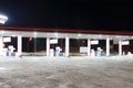 Empty petrol station with illumination at dark winter night