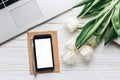 Empty phone screen and laptop and tulips on white wooden rustic Royalty Free Stock Photo