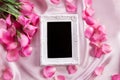 Empty photo frame with a bouquet sweet pink roses petal on sof