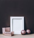 Empty photo frame on brown wall with pink christmas decoration. Styled winter holiday image. Elegant and classy christmas home