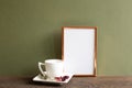 Empty photo frame with coffee cup and dry flowers on wooden table Royalty Free Stock Photo