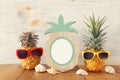 Empty photo frame and couple of funny pineapple with sunglasses. For photography and scrapbook montage Royalty Free Stock Photo